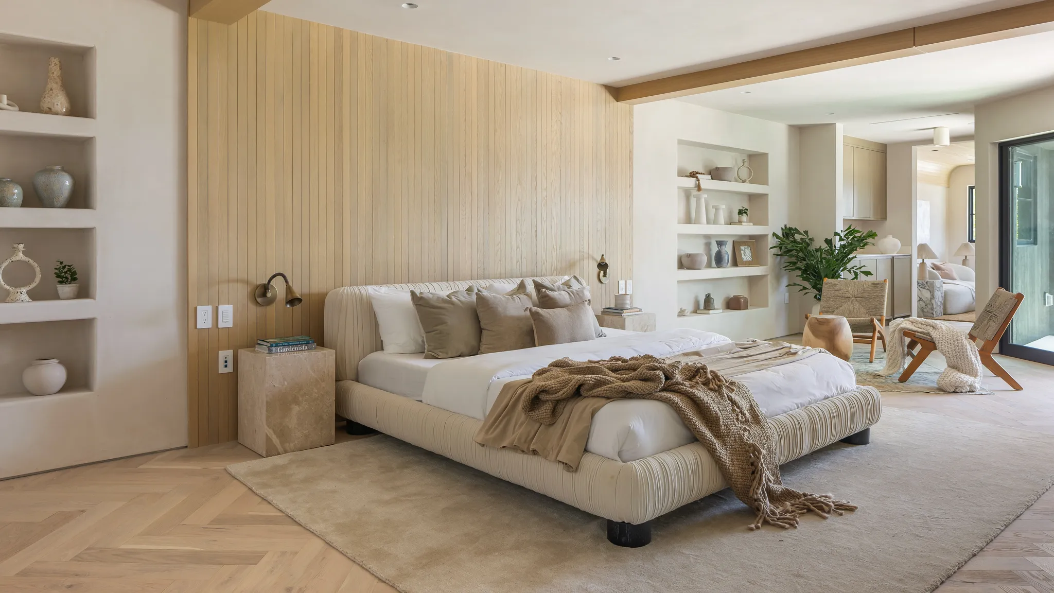 The rug should extend at least 18 inches past the sides of the bed. Smaller rugs make the room feel smaller, not bigger.